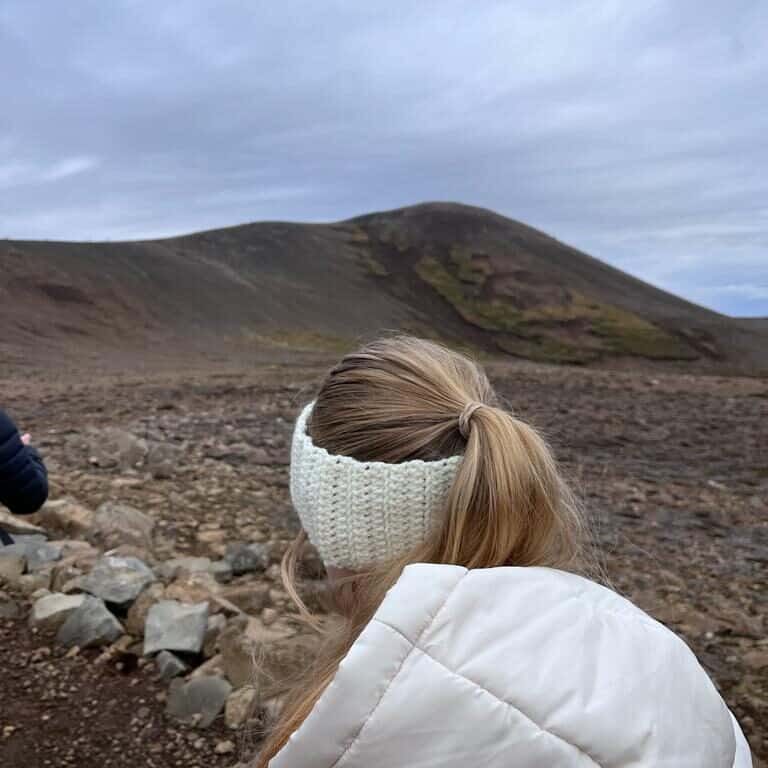 Girl walks away from the camera while hiking in the volcanic area
