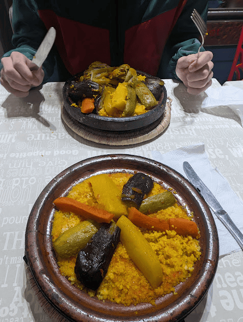 Two plates of tagine - one with vegetables and one with meat